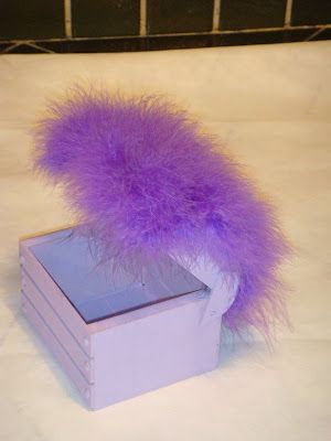 Caixa pequena com pompom na tampa.